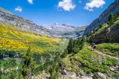 Ordesa 'daki Cola de Caballo şelalesine giden yürüyüşçüler ve Monte Perdido Ulusal Parkı, Aragon, Huesca, İspanya.