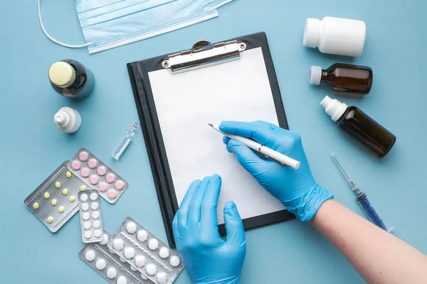 Doktorlar eldiven veriyorlar. Kovid 19 aşısını tutuyorlar ve kalemle yazıyorlar. Aşı ve aşı geliştirme konsepti, aşı üzerinde çalışmak. Doktor masasını hazırla. Şırınga ve aşı şişesi.