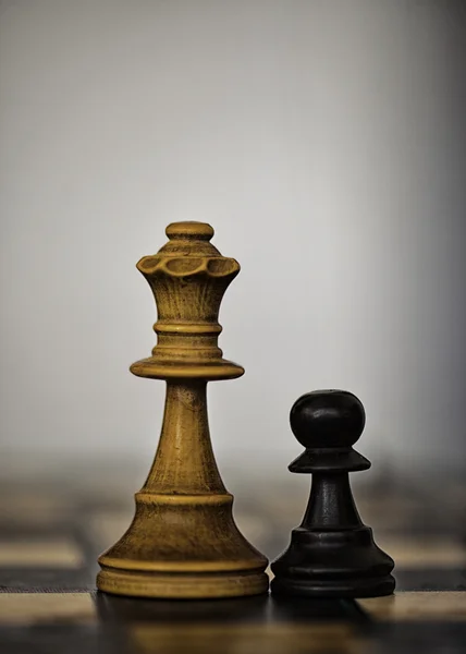 Bílá královna a černý pěšec šachové figurky — Stock fotografie
