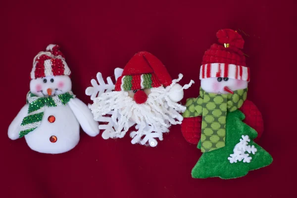 Santa claus i dwa bałwanki na czerwonym tle — Zdjęcie stockowe