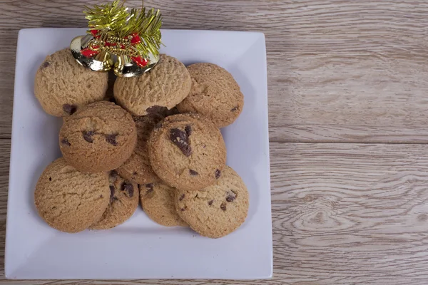 Plate of chocolate chip cookies with christmas decorations — Stock Photo, Image