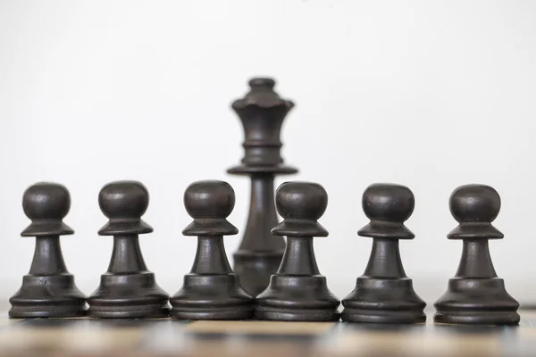 Houten zwarte koningin en pionnen schaakstukken — Stockfoto