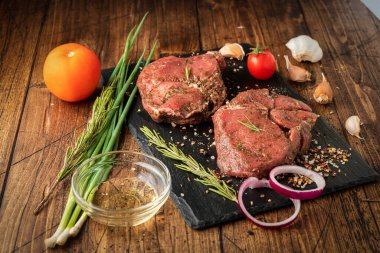 Siyah tahtada bir parça et ve sebze.