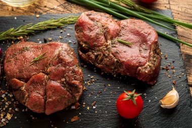 Siyah tahtada bir parça et ve sebze.