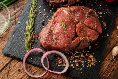 Siyah tahtada bir parça et ve sebze.