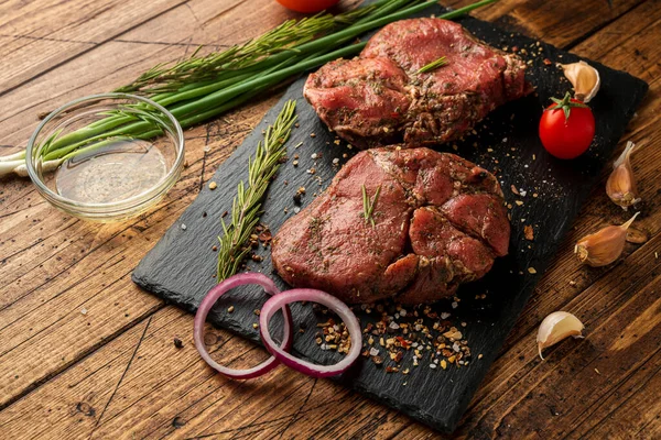 Siyah tahtada bir parça et ve sebze.