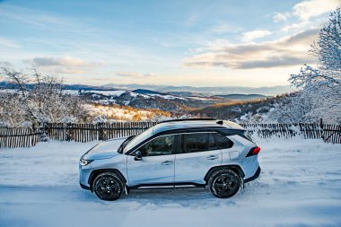 Uzhhorod, Ukraine. January, 2021. Gray car of the Japanese brand Toyota RAV 4 hybrid. SUV, crossover. Reliable and beautiful car. Car in the winter mountains.	