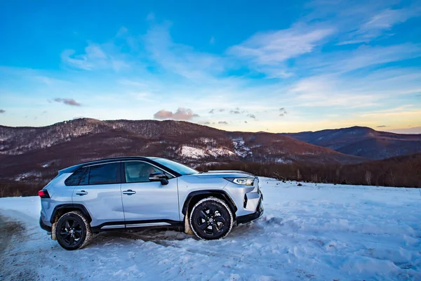 Uzhhorod, Ukraine. January, 2021. Gray car of the Japanese brand Toyota RAV 4 hybrid. SUV, crossover. Reliable and beautiful car. Car in the winter mountains.	