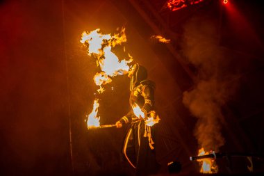 Uzhhorod, Ukrayna - 30 Nisan 2018: Ateş Bayramı. Adam ateş yakıyor. Festivaldeki ateş dikişlerinin bulanık arkaplanı. 