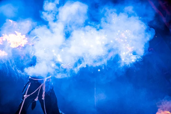 Uzhhorod, Ukrayna - 30 Nisan 2018: Ateş Bayramı. Adam ateş yakıyor. Festivaldeki ateş dikişlerinin bulanık arkaplanı. 