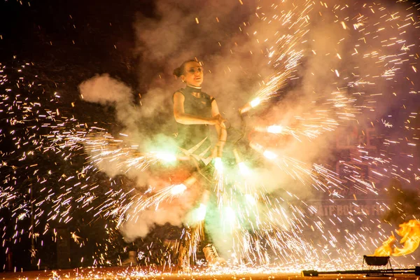 Uzhhorod, Ukrayna - 30 Nisan 2018: Ateş Bayramı. Adam ateş yakıyor. Festivaldeki ateş dikişlerinin bulanık arkaplanı. 