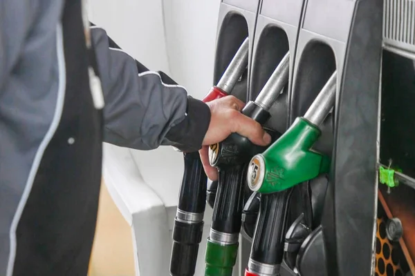 Oil crisis. Refuel fill up with petrol gasoline. Petrol pump filling fuel nozzle in gas station. Fuel dispenser machine. Petrol industry and service. Red petrol fuel nozzle. Petroleum oil industry.