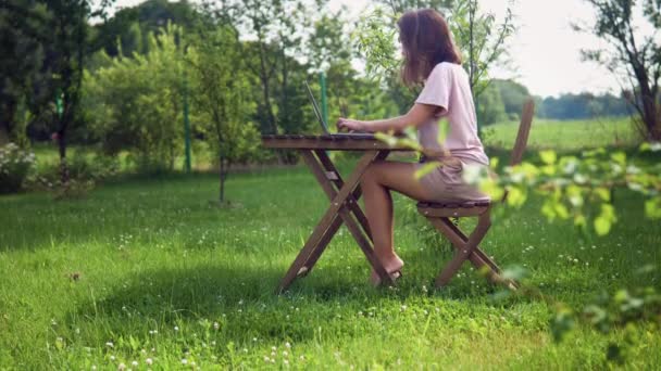 Egy nő laptoppal dolgozik a gardjában. — Stock videók