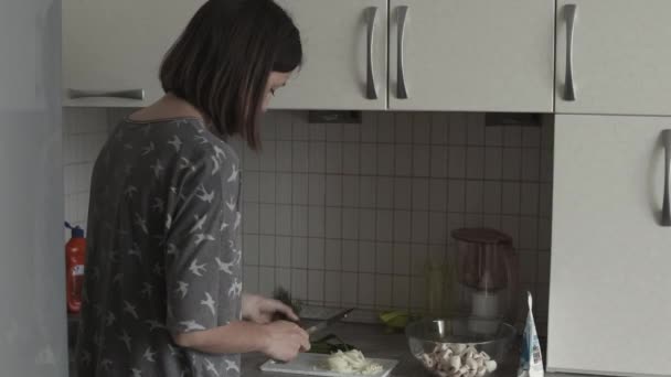 Egy nő vacsorát készít a konyhában. — Stock videók