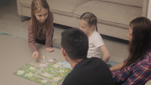 Familia pasa el tiempo jugando juegos de mesa — Vídeo de stock