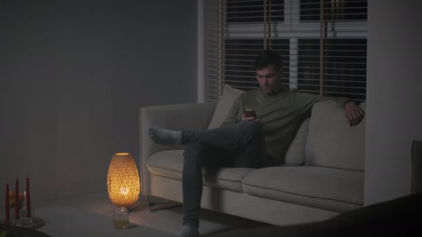 Man browsing his phone at night — Video