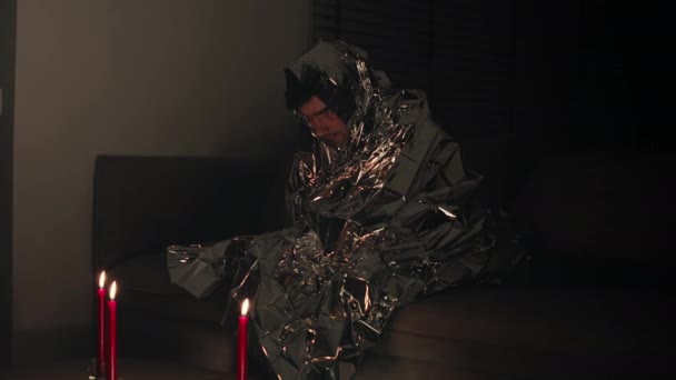 Man duduk ditutupi oleh selimut foil — Stok Video