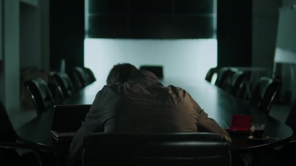 A man does drugs in empty office at night. — Video