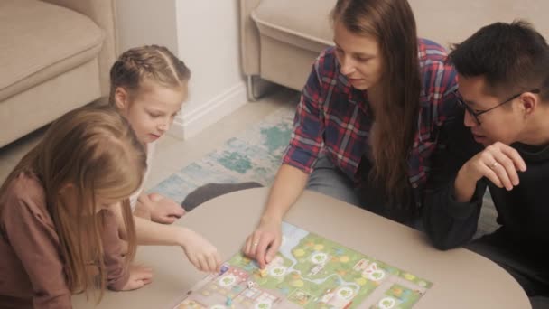 Parents spends the evening playing board games with children — Vídeo de stock