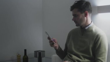 Geceleri cep telefonuna bakan adam