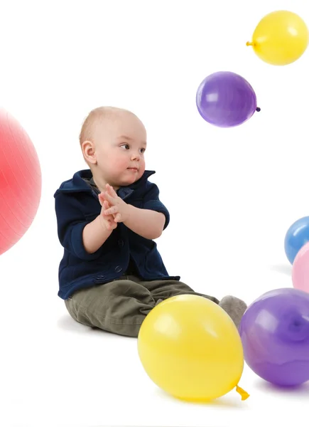 Das kleine Kind spielt mit Bällen — Stockfoto