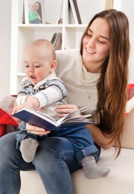 genç anne çocuğa kitap okur.