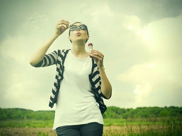 Girl blowing soap bubbles — Stock Photo, Image