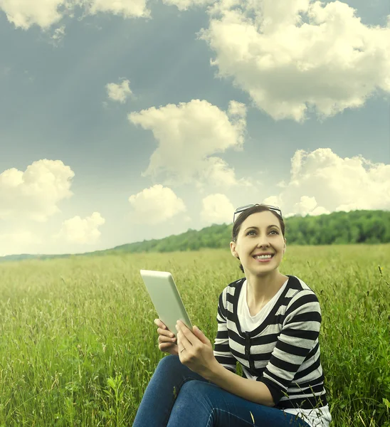 Menina com tablet no parque na grama . — Fotografia de Stock