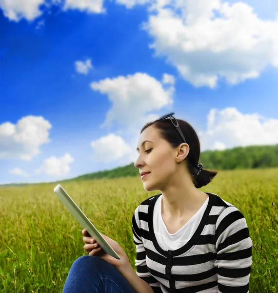 Mädchen mit Tablet-PC im Gras. — Stockfoto