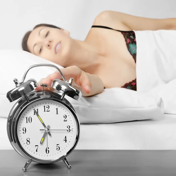 Woman turning off her alarm clock — Stock Photo, Image