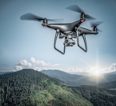 Dağların üzerinde uçan kara drone.