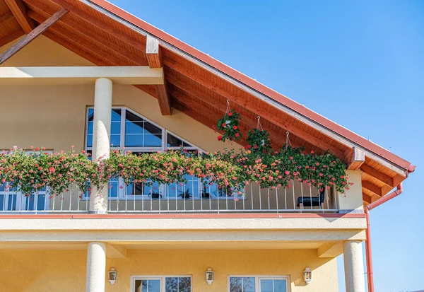 Parte da casa com um belo terraço e uma varanda com flores. — Fotografia de Stock