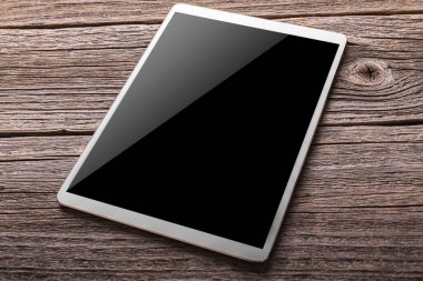 Ahşap masa üzerinde beyaz dijital tablet
