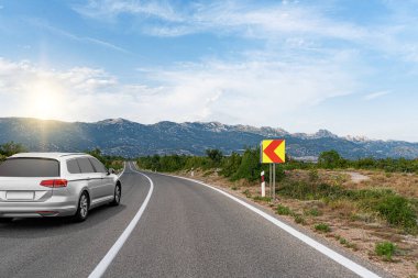 Araba yol boyunca gidiyor. Banliyö yolunda beyaz bir araba..