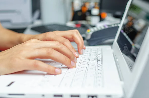Жінка друкує на білій клавіатурі ноутбука . — стокове фото