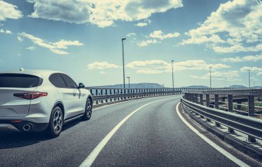 Araba yol boyunca gidiyor. Banliyö yolunda beyaz bir araba..