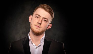 Siyah takım elbiseli yakışıklı bir adam..