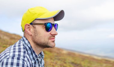 Şapkalı ve gözlüklü genç bir adam..