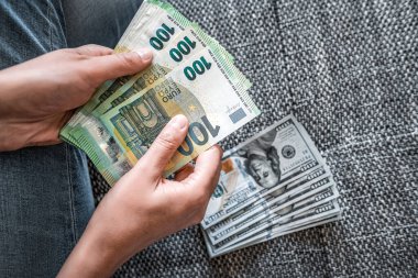 Euros and dollars in female hands. Dollar to euro exchange rate - concept.