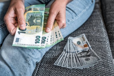 Euros and dollars in female hands. Dollar to euro exchange rate - concept.