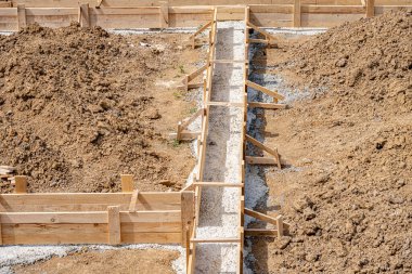 Wooden formwork for pouring concrete foundation of the house. Foundation construction.