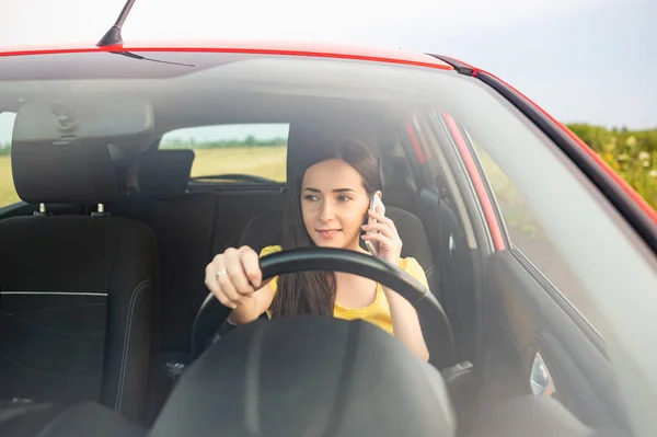 Young Woman Using Smartphone While Driving Car — Stockfoto