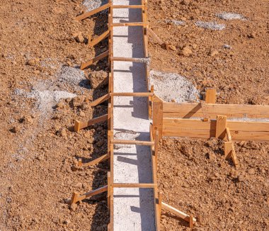 Wooden formwork for pouring concrete foundation of the house. Foundation construction.