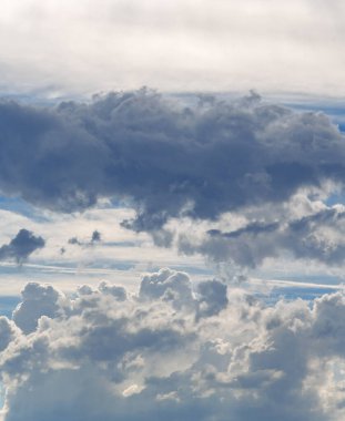 Sky with clouds. White cumulus clouds against a cloudy dramatic sky.