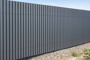 Demir çit ve mavi gökyüzü. Profilli bir çarşaftan beyaz bulutlu bir çit..