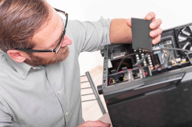 Bir uzman bir bilgisayarı tamir eder. Kişisel bilgisayarların onarımı, montajı ve restorasyonu.