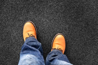 Sarı ayakkabılı ve kot pantolonlu bacaklar..