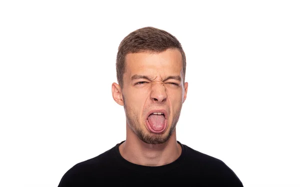 stock image A young man and makes a disgusted grimace on a white background.