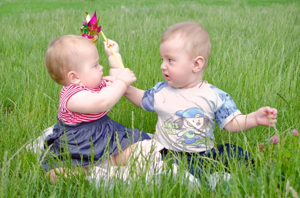 Petit garçon et fille jouant sur l'herbe verte — Photo