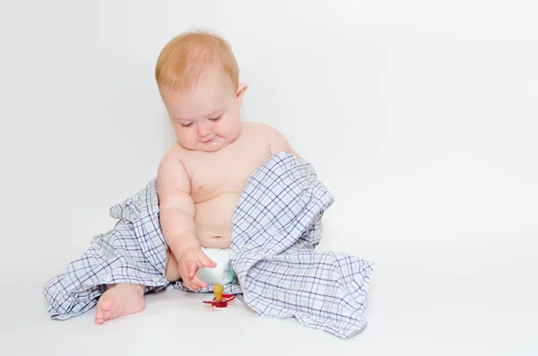 Bebé en una camisa alcanzando su chupete — Foto de Stock